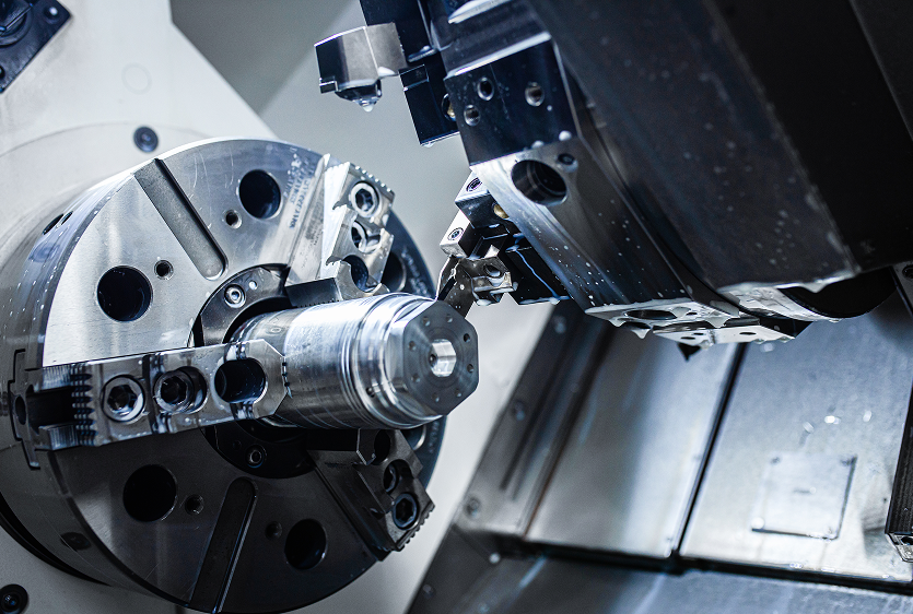 Five-axis CNC milling machine cutting a metal part